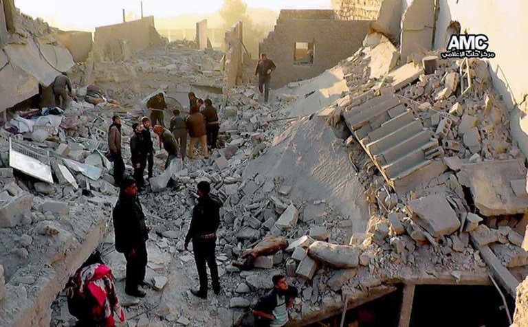 In this Monday, Jan. 6, 2014 citizen journalism Image provided by Aleppo Media Center, AMC, which has been authenticated based on its contents and other AP reporting, Syrians inspect the rubble of destroyed buildings following a Syrian government airstrike in Aleppo, Syria. (AP Photo/Aleppo Media Center AMC)