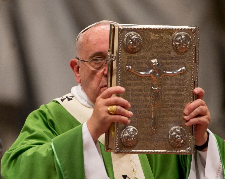 Pope Francis hoists the Gospel book as he celebrates a mass in St. Peter's Basilica at the Vatican, Sunday, Oct. 5, 2014 to open the extraordinary Synod on the family. Pope Francis on Sunday opened a two-week meeting of bishops and cardinals from around the world aimed at making the church's teaching on family life â marriage, sex, contraception, divorce and homosexuality â relevant to today's Catholic families. (AP Photo/Alessandra Tarantino)