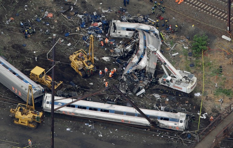 In this aerial photo, emergency personnel work at the scene of a deadly train wreck, Wednesday, May 13, 2015, in Philadelphia. Federal investigators arrived Wednesday to determine why an Amtrak train jumped the tracks in a wreck that killed at least six people, and injured dozens. (AP Photo/Patrick Semansky)