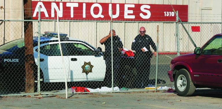 Fresno police officers look over the area where a man killed himself after shooting people in his workplace that killed at least one person and wounded several others at Valley Protein, formally known as Apple Valley Farms Tuesday, Nov. 6, 2012, in Fresno, Calif. Police say a parolee who worked at the Fresno chicken processing plant opened fire at the business on Tuesday, killing one person and wounding three others, before shooting himself. Police Chief Jerry Dyer said they didn't know what prompted the attack by 42-year-old Lawrence Jones midway through his shift at Apple Valley Farms. Other workers told police he did not appear to be himself when he arrived at the plant for work.(AP Photo/Gary Kazanjian)