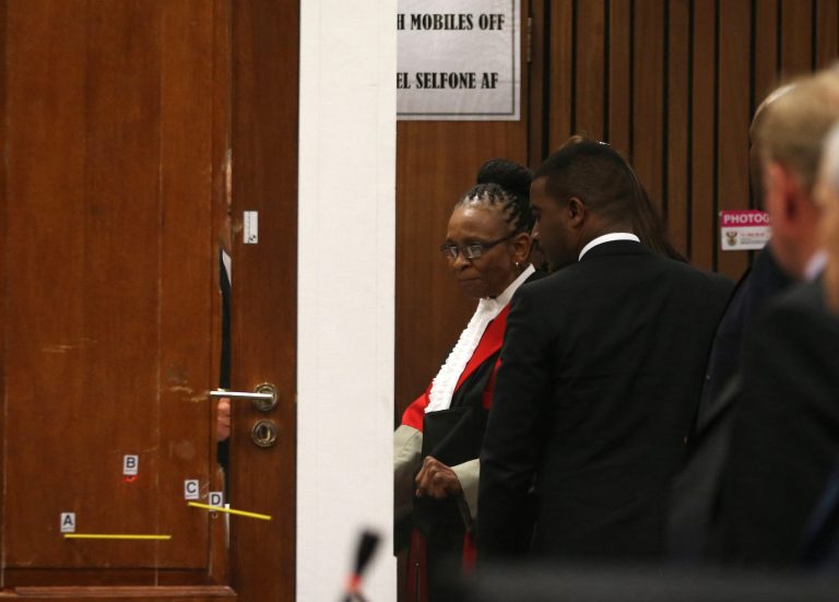 File: In this Friday, May 9, 2014 file photo Judge Thokozile Masipa, to right of door in red cape, and her advocates examine the bullet-riddled toilet door up close during expert forensics evidence being given at the Oscar Pistorius murder trial in in Pretoria, South Africa. Judge  Masipa is expected to announce her verdict after summing up Thursday and Friday  in Pistorius' murder trail after scrutinizing evidence given by 37 witnesses in a court transcript running to thousands of pages in a drama that has played out over six months.  (AP Photo/Themba Hadebe, Pool, File)
