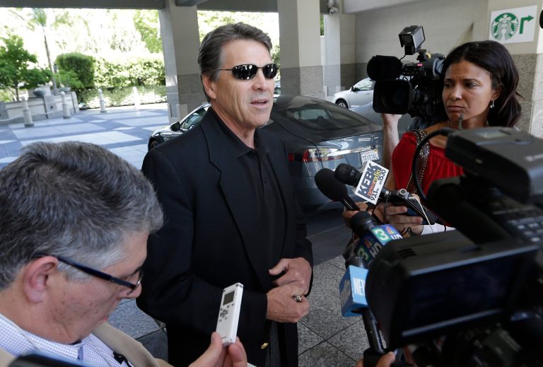 FILE - In this June 10, 2014 file photo, Texas Gov. Rick Perry, center, talks to reporters after driving up in a Tesla Motors Type S electric car in Sacramento, Calif. On Thursday, June 19, 2014, Perry said it was a mistake for him to recently compare alcoholism and homosexuality in an effort to explain his views. (AP Photo/Rich Pedroncelli, File)