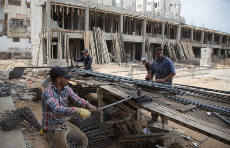 Palestinian construction laborers work on a U.N. school in the Gaza Strip, Saturday, Oct. 11, 2014. After the Gaza war, the U.N. brokered a deal with Israel and the Palestinian government under which Israel is to allow imports of construction materials for the private sector. On the Gaza side, the shipments are to be tracked by U.N. and Palestinian officials. (AP Photo/Khalil Hamra)