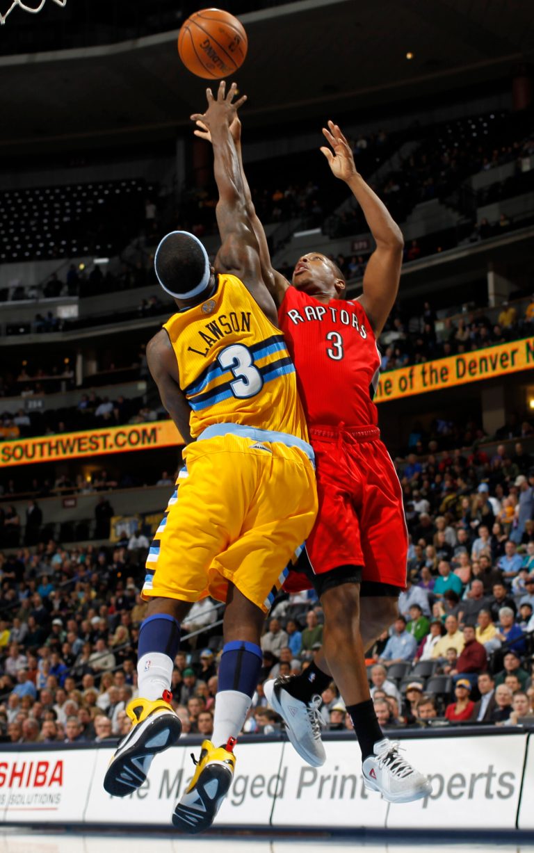   Denver Nuggets guard Ty Lawson, left, blocks a shot by Toronto Raptors guard Kyle Lowry during the first quarter of an NBA basketball game in Denver on Monday, Dec. 3, 2012. (AP Photo/David Zalubowski)  