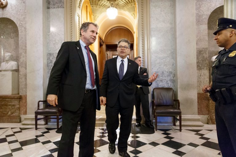 Sen. Sherrod Brown, D-Ohio, left, and Sen. Al Franken, D-Minn., leave the chamber during the vote on restoring jobless benefits for the long-term unemployed, legislation that expired late last year, at the Capitol in Washington, Monday, April 7, 2014. With their 17-day spring break beckoning at the end of the week, House and Senate lawmakers will have to scramble to reach agreement. (AP Photo/J. Scott Applewhite)