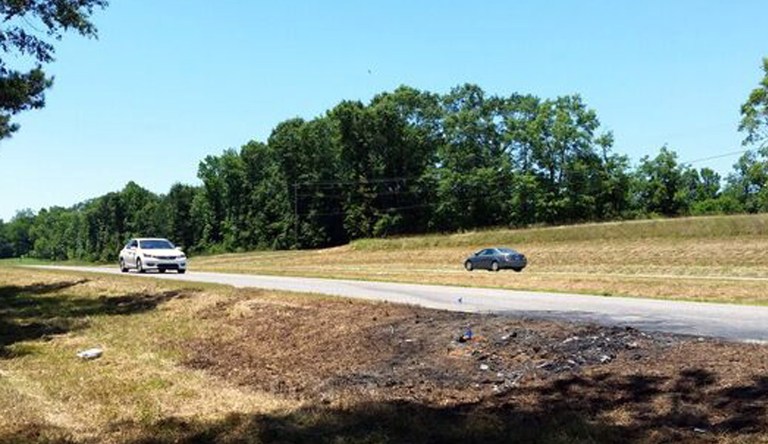 Cars pass charred ground at the scene of a fatal traffic accident in rural Tuscaloosa County, Ala. (AP Photo/Phillip Lucas)