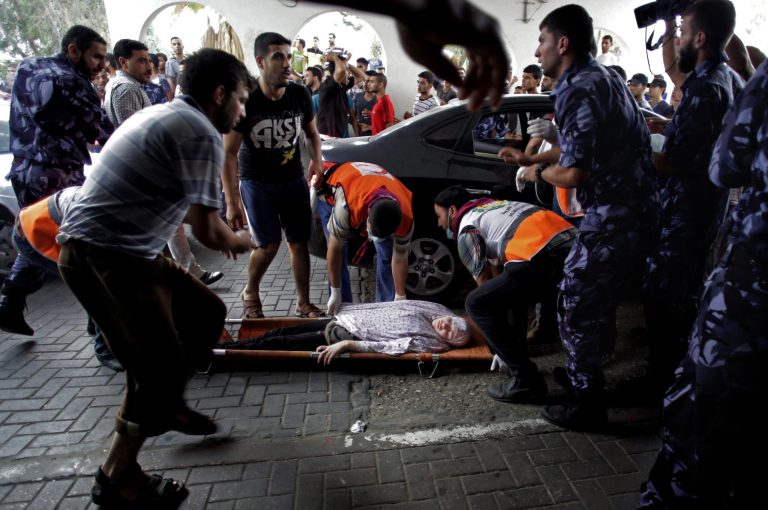 Palestinian medics carry a wounded woman to an emergency room at Shifa hospital in Gaza City, Sunday, July 20, 2014. In the heart of Gaza City, as its citizen again find themselves under fire from Israeli airstrikes and artillery, the wounded and their wailing families stream into Shifa Hospital without end. (AP Photo/Khalil Hamra)