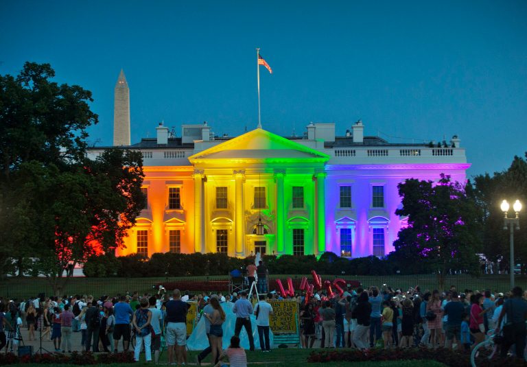 In this Friday, June 26, 2015 file photo, people gather in Lafayette Park to see the White House illuminated with rainbow colors in commemoration of the Supreme Court's ruling to legalize same-sex marriage in Washington. (AP Photo/Pablo Martinez Monsivais)