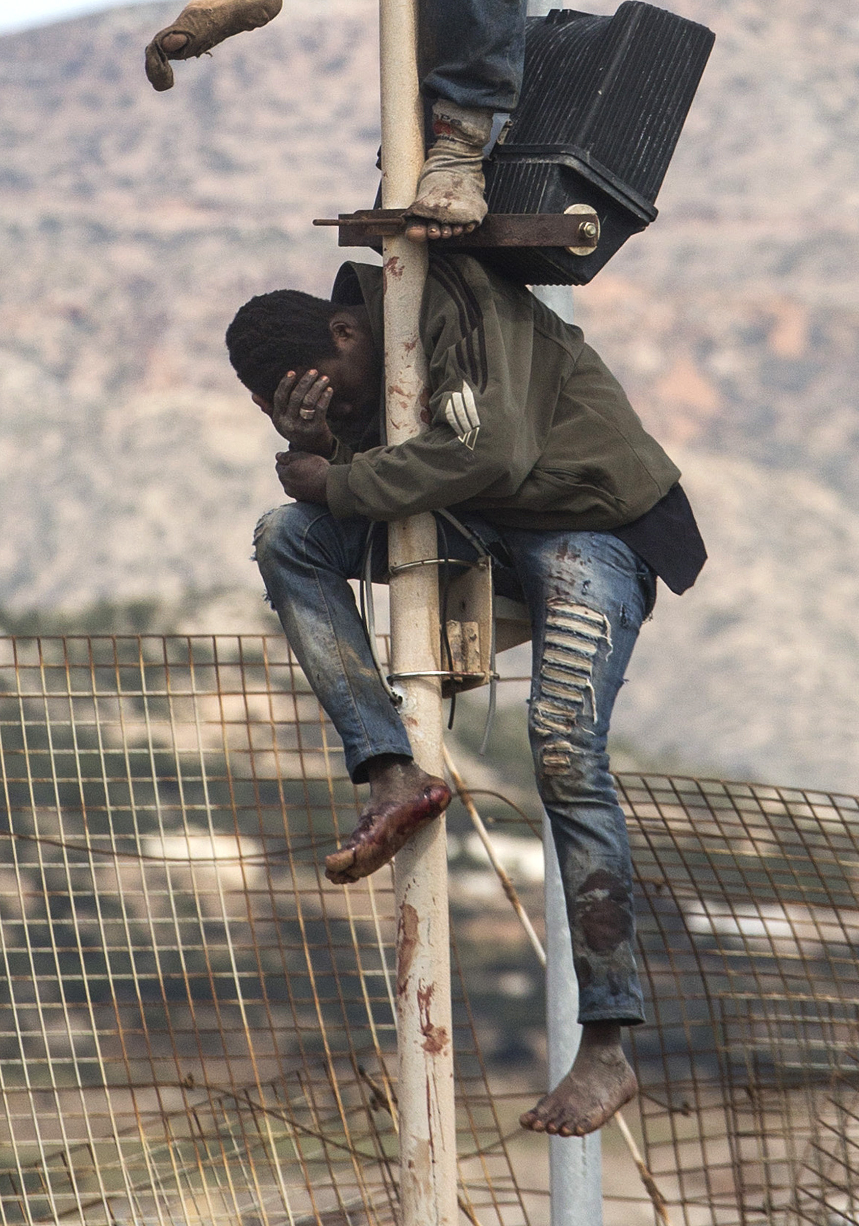 Migrants perched on fence after bid to enter Spain