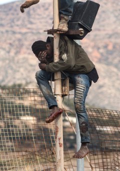 Migrants perched on fence after bid to enter Spain