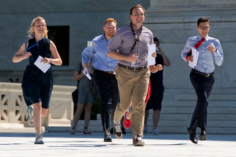 New interns run with a decision across the plaza of the Supreme Court in Washington, D.C. (AP Photo/Jacquelyn Martin)