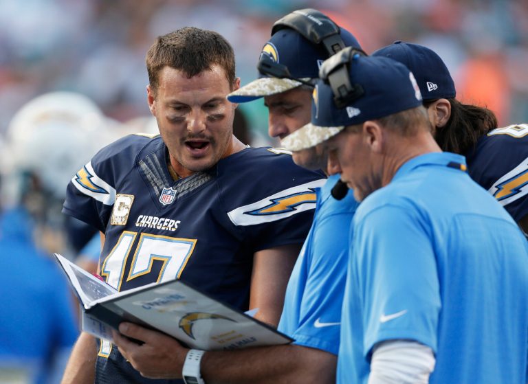 FILE - In this Nov. 17, 2013, file photo, San Diego Chargers quarterback Philip Rivers (17) reviews plays on the sidelines during the first half of an NFL football game against the Miami Dolphins in Miami Gardens, Fla. NFL teams used to take Polaroid pictures of plays from atop the stadium during games then send them down to the field on a rope. Technology improved so that an automated camera could deliver the images to a printer on the sideline, creating that familiar sight of a quarterback staring at a sheet of paper to figure out what went wrong on an interception. That was still the case last season, when fans in the stands could watch highlights on their smartphones, but players and coaches were flipping through three-ring binders of black-and-white photos. (AP Photo/Lynne Sladky, File)
