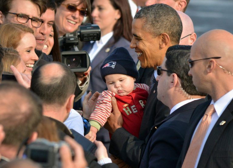 President Barack Obama holds six-month-old Ty Harrison as his mother Mary Harrison of Winthrop, Mass., watches as the president greeted supporters after arriving at Logan Airport in Boston, Wednesday, Oct. 30, 2013. The president was to speak about the federal health overhaul law at Faneuil Hall, where former Massachusetts Gov. Mitt Romney, joined by the late Massachusetts Sen. Ted Kennedy to sign the state's 2006 health care overhaul bill. (AP Photo/Josh Reynolds)