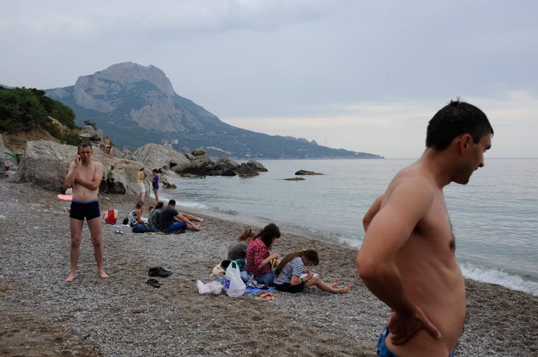 Russian tourists rest on the Black Sea beach about 35 km. (22 miles) from Yalta, Crimea, Sunday, June 15, 2014. When Russia annexed the Black Sea peninsula of Crimea earlier this year, it regained not only harbors for its navy and abandoned Ukrainian military bases but also long stretches of pebble beaches that were the summer destination of choice for millions of Soviet citizens. The Kremlin is hoping to attract tourists to Crimea, which Russia annexed in March, by asking state-controlled companies to send their employees on free vacation trips.(AP Photo/Andrew Lubimov)