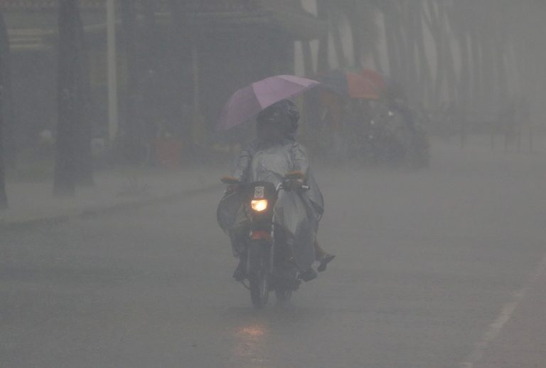 A Filipino drives his motorcycle despite low visibility caused by heavy rains along a promenade at Manila's bay, Philippines on Monday, Aug. 4, 2014. Philippine officials say Typhoon Halong has worsened monsoon rains, flooding northern villages, but is too far off at sea to hit the country as it blows toward southern Japan. (AP Photo/Aaron Favila)