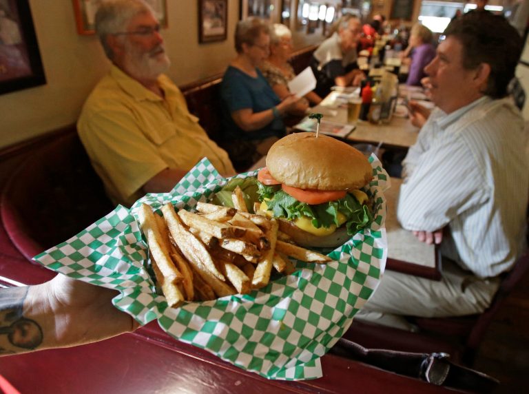   FILE - In this Wednesday, Aug. 21, 2013, file photo, server Taryn Yanez holds a cheeseburger order at The Nook in St. Paul, Minn. The Institute for Supply Management issues its U.S. non-manufacturing (service-sector) index for August on Thursday, Sept. 5, 2013. (AP Photo/Jim Mone, File)  