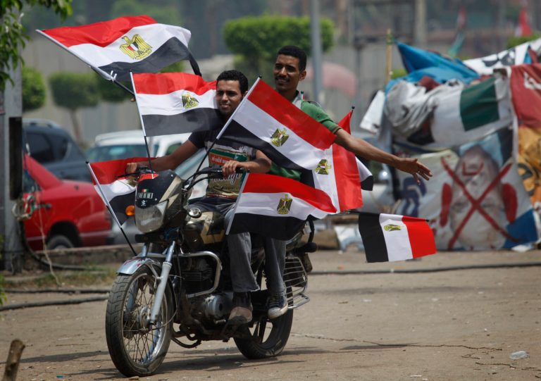   Two supporters of presidential candidate, Mohammed Morsi ride a motorcycle flying Egyptian flags during celebrations claiming victory over rival candidate, Ahmed Shafiq, in Tahrir Square, Cairo, Egypt Monday, June 18, 2012. The Muslim Brotherhood declared early Monday that its candidate, Mohammed Morsi, won Egypt's presidential election, which would be the first victory of an Islamist as head of state in the stunning wave of protests demanding democracy that swept the Middle East the past year. (AP Photo/Nasser Nasser)  