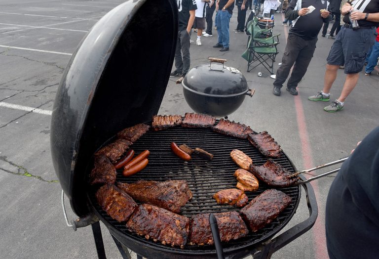 A tailgater barbeques meat in the parking lot prior to the San Francisco 49ers and Oakland Raiders football game at O.co Coliseum on December 7, 2014 in Oakland, California. (Photo by Thearon W. Henderson/Getty Images)
