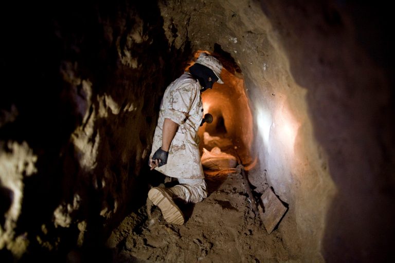 A Mexican Army soldier using a flashlight to shows reporters a tunnel connecting warehouses on either side of California's border with Mexico in Tijuana. More than 75 such underground passages have been found along the border since 2008, concentrated largely in California and Arizona. (AP Photo/Guillermo Arias)