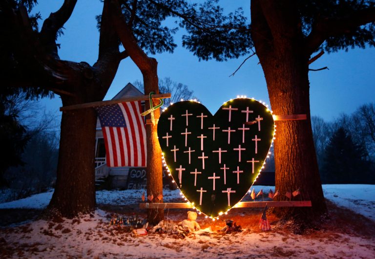 In this Dec. 14, 2013 file photo, a makeshift memorial with crosses for the victims of the Sandy Hook Elementary School shooting massacre stands outside a home in Newtown, Conn. (AP Photo/Robert F. Bukaty, File)