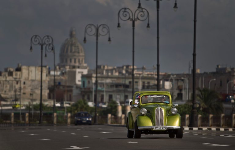 In this Oct. 15, 2014 photo, a man drives a classic American car on The Malecon in Havana, Cuba. This classic still running on the streets of Havana is part of a fleet of classic cars that have become an icon of tourism in the socialist nation. (AP Photo/Franklin Reyes)