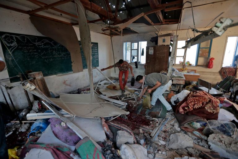 Palestinians collect body parts in a classroom at Abu Hussein U.N. school in Jebaliya refugee camp, northern Gaza Strip, Wednesday, July 30, 2014. Shelling of a school crowded with refugees in Gaza early Wednesday killed at least 17 people and wounded 90 more, according to Palestinian health officials.  (AP Photo/Lefteris Pitarakis)