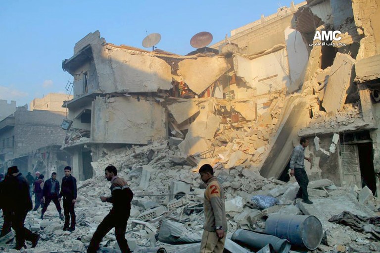 In this Sunday, Dec. 15, 2013 citizen journalism image provided by Aleppo Media Center, AMC, which has been authenticated based on its contents and other AP reporting, Syrians inspect the rubble of damaged buildings following a Syrian government airstrike in Aleppo, Syria. The Britain based Syrian Observatory for Human Rights said Monday that dozens of children were among scores killed in airstrikes on several opposition areas a day earlier. (AP Photo/Aleppo Media Center AMC)