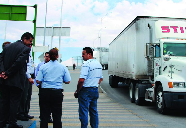 File- In this July 5, 2012 file photo, attorney Emilio de La Rosa, left, and forensics expert Mario Gomez, right, talk to a customs and court officials at the Las Americas Bridge in Juarez, Mexico while doing a reconstruction of the events that lead to the arrest of trucker Jabin Bogan. Bogan was taken into custody April 17, 2012 with 268,000 bullets in Mexico. A Mexican appeals judge on Thursday significantly lessened the charge Bogan who says he made a wrong turn into Mexico. (AP Photo/ Juan Carlos Llorca, File)