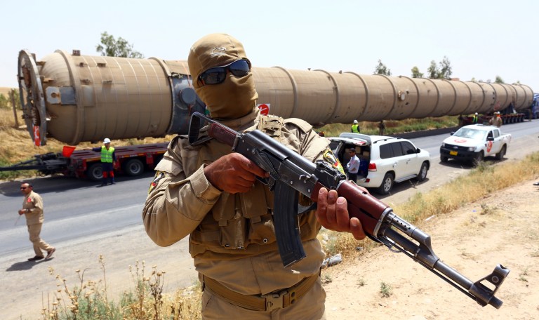 A Kurdish Peshmerga fighter stands guard as new equipment arrives at Kalak refinery on the outskirts of Irbil, Iraq, Monday, July 14, 2014, as Kurdish authorities are trying to help ease the fuel shortage. (AP Photo)