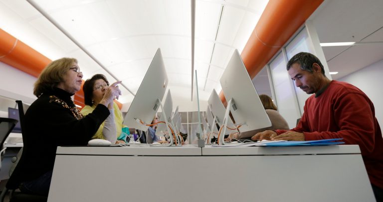 FILE - In this Wednesday, Dec. 11, 2013, file photo, Caroline Ramirez, left, and Sam Martinez, right, use computers at a public library to access the Affordable Health Care Act website, in San Antonio. Health care workers and officials in Texas on Monday, Dec. 23, 2013, rushed to sign people up for insurance plans, even after receiving a one-day extension on a deadline for customers buying coverage under the new federal health care law to have their plans kick in Jan. 1. (AP Photo/Eric Gay, File)