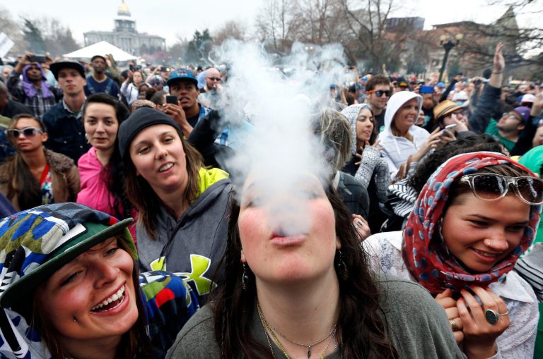In this April 19, 2014 file photo, partygoers dance and smoke pot on the first of two days at the annual 4/20 marijuana festival in Denver. (AP Photo/Brennan Linsley, File)