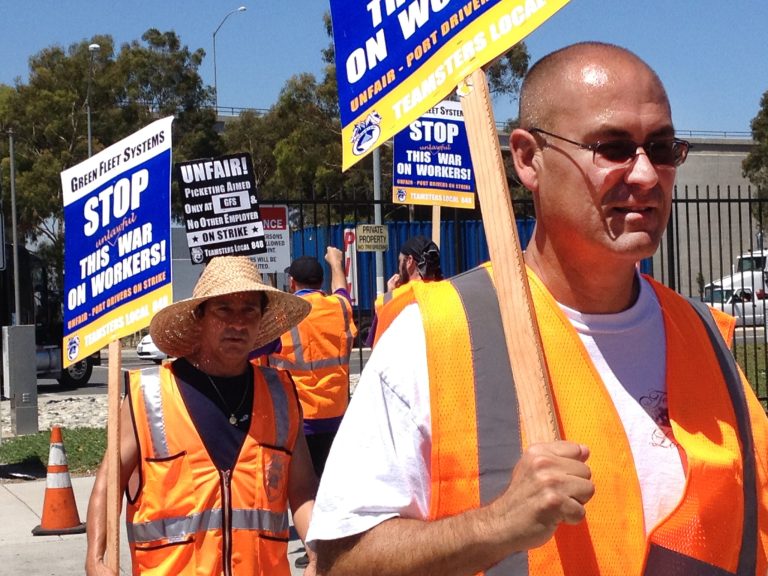 Truck drivers and supporters picket outside the offices of Green Fleet Systems in Carson, Calif., on Monday, July 7, 2014. The truckers say the companies have prevented them from unionizing and improperly classified them as contractors, rather than full-time employees, to minimize wages and benefits. (AP Photo/Matt Hamilton)