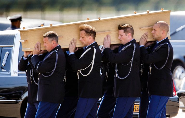 Pallbearers carry a coffin towards a hearse during a ceremony to mark the return of the first bodies, of passengers and crew killed in the downing of Malaysia Airlines Flight 17, from Ukraine at Eindhoven military air base, the Netherlands, Wednesday, July 23, 2014. After being removed from the planes, the bodies are to be taken in a convoy of hearses to a military barracks in the central city of Hilversum, where forensic experts will begin the painstaking task of identifying the bodies and returning them to their loved ones. (AP Photo/Phil Nijhuis)