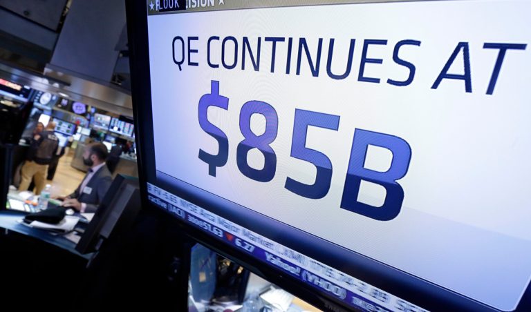 The decision of the Federal Reserve appears on a television screen on the floor of the New York Stock Exchange Wednesday, Oct. 30, 2013. The Fed says in a statement after a two-day policy meeting that it will keep buying $85 billion a month in bonds to keep long-term interest rates low and encourage more borrowing and spending.  (AP Photo/Richard Drew)