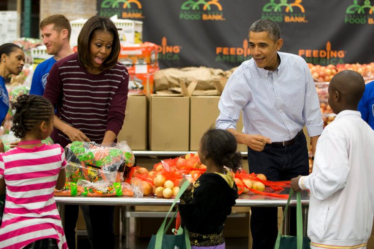 President Barack Obama, right, and first lady Michelle Obama participate in a Thanksgiving service project by handing out food at the Capital Area Food Bank on Wednesday, Nov. 27, 2013 in Washington. The Capital Area Food Bank distributes 30 million pounds of food annually. (AP Photo/ Evan Vucci)
