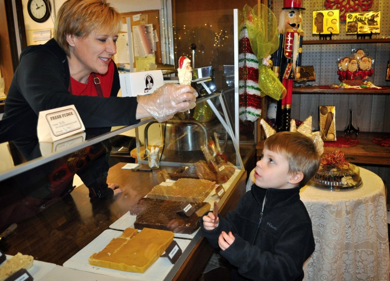 FILE - In this Nov. 30, 2013 file photo, Brody Clark, 4, of Paducah, Ky., receives a Christmas treat from Jeinine Searcy while his family shops around The Chocolate Factory during Small Business Saturday in Paducah, Ky. Heath care, Internet security and new technology are among the list of things that small businesses need to be on top of over the next several months. (AP Photo/The Paducah Sun, Allie Douglass, File)