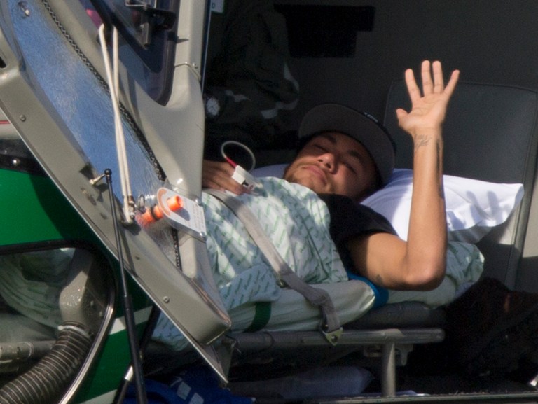 Brazil's Neymar waves as he lies inside a medical helicopter at the Granja Comary training center, in Teresopolis, Brazil, Saturday, July 5, 2014. Neymar was airlifted from Brazil's training camp Saturday and will be treated at home for his back injury. Neymar, the biggest football star in Brazil, was ruled out of the rest of the World Cup after fracturing his third vertebra during Friday's 2-1 quarterfinal win over Colombia. (AP Photo/Leo Correa)