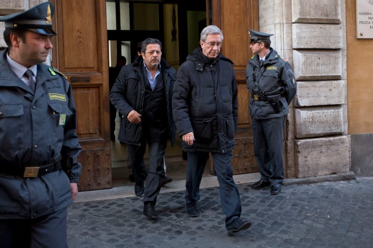 Rev. Franco Decaminada, second right, leaves an Italy's financial police barrack after being questioned in Rome, Thursday, April 4, 2013. Italian police have arrested a Catholic priest accused of pocketing 4 million euros ($5.1 million) from the coffers of a Catholic hospital he ran and helping run up 600 million euros in debts that forced the clinic into bankruptcy and prompted the Vatican to intervene. Italy's financial police placed the Rev. Franco Decaminada, until 2011 the CEO of the IDI dermatological hospital in Rome, under house arrest Thursday and detained two other people while seizing a Tuscan farmhouse police say he purchased with stolen money. (AP Photo/Andrew Medichini)