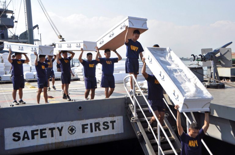   In this photo released by the Philippine Navy, navy personnel carry donated coffins on Philippine Navy ship BRP Laguna (LT-501) at the Sangley Point Naval Base, Cavite province, southern Philippines on Tuesday, Dec. 11, 2012 as it prepares to go to typhoon-affected areas of the country. Typhoon Bopha hit the main southern island of Mindanao last Tuesday, killing hundreds of people, mostly from flash floods that wiped away precarious communities in the southern region unaccustomed to typhoons. (AP Photo/Philippine Navy, SN2 Michael D. Namit) NO SALES  