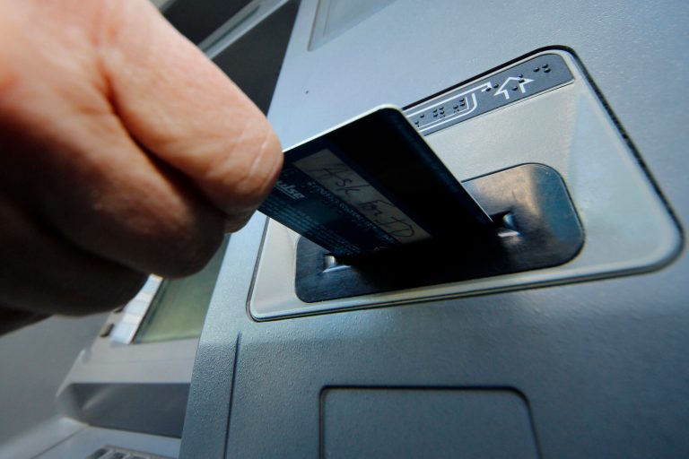 FILE - In this Saturday, Jan. 5, 2013 photo, a person demonstrates using a credit card in an ATM in Pittsburgh. The Federal Reserve on Monday, April 7, 2014 will release a report on how much consumers borrowed in February. (AP Photo/Gene J. Puskar, File)