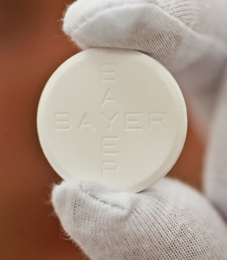 In this photo taken July 6, 2009 worker Roland Ulbrich presents an Aspirin pill made for Italy at the pharmaceutical plant of the Bayer Bitterfeld company in Bitterfeld-Wolfen, eastern Germany.  Germany's Bayer AG says it plans to buy U.S. pharmaceutical company Merck & Co. Inc.'s consumer care business, whose products include the Coppertone suncare range, Claritin allergy medicine and the Dr. Scholl's footcare products, for US$ 14.2 billion. (AP Photo/Eckehard Schulz)
