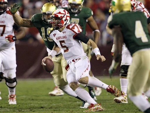 Maryland quarterback Danny O'Brien (5) looks for a receiver as he is pressured by Notre Dame defenders in the first half of an NCAA college football game in Landover, Md., Saturday, Nov. 12, 2011. (AP Photo/Patrick Semansky)