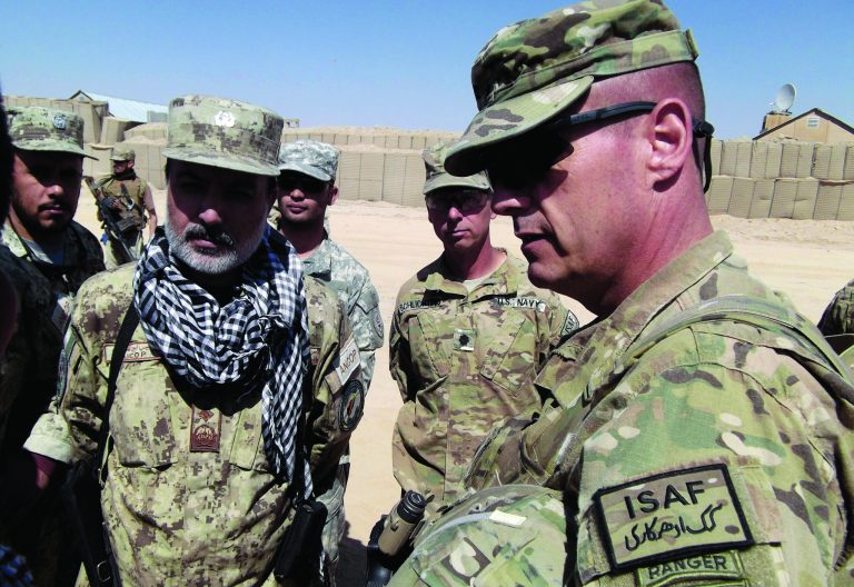 This photo taken Oct. 10, 2012 shows U.S. Brig. Gen. John Charlton, right, talking with Afghan National Civil Order Police (ANCOP) brigade commander Gul Mohammed Rasikh at the U.S base in An Band district, Ghazni province, Afghanistan. Fed up with the Taliban closing their schools and committing other acts of oppression, men in a village about 100 miles south of Kabul took up arms late last spring and chased out the insurgents with no help from the Afghan government or U.S. military. Small-scale revolts like the one in the village of Kunsaf, Ghazni, in recent months indicate bits of a do-it-yourself anti-insurgency that the U.S. hopes Afghan authorities can transform into a wider movement that could undercut the Taliban in areas it still dominates after 11 years of war. (AP Photo/Robert Burns)