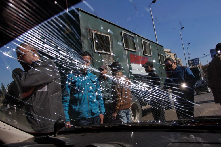 Egypt's security forces look through the shuttered windshield of a vehicle damaged after bomb explosions targeted at a checkpoint in Giza, Egypt, Friday, Feb. 7, 2014. Twin homemade bombs targeting a police checkpoint wounded several people on a bridge in Cairo's twin city of Giza Friday morning, the latest apparent attack by militants near the center of the Egyptian capital. (AP Photo/El Shorouk, Aly Hazzaa) EGYPT OUT