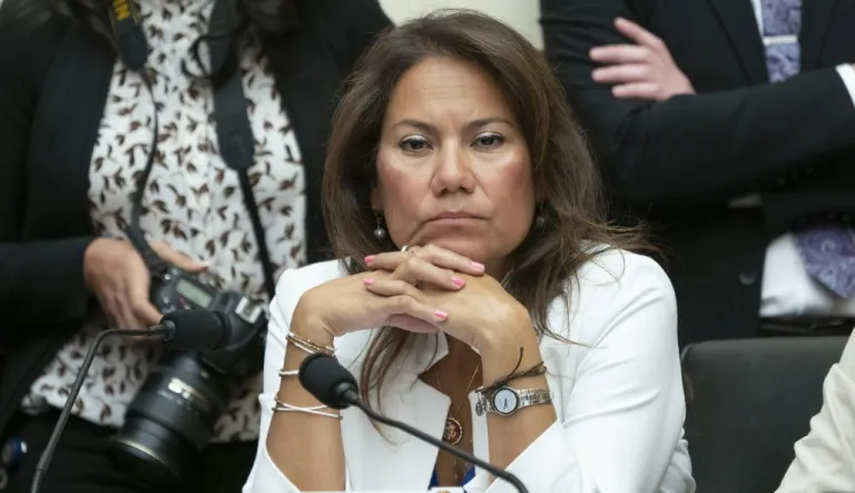 Rep. Veronica Escobar looking beyond her with hands clasped and microphone in front of her.