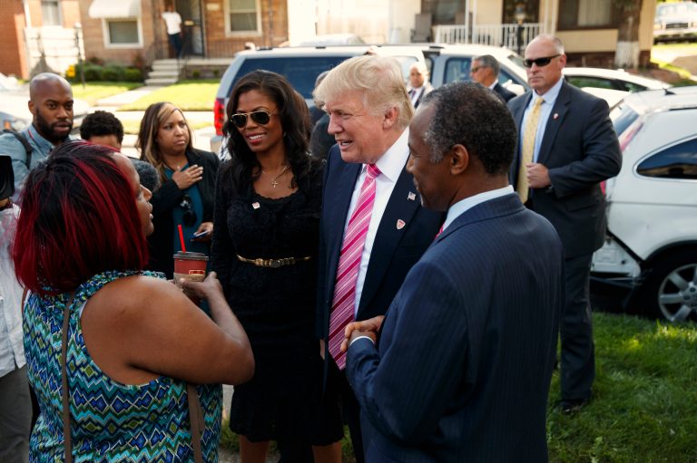 Neighborhood resident Felicia Reese, left, talks with Republican presidential candidate Donald Trump and Dr. Ben Carson, during a tour of Carson's childhood home, Saturday, Sept. 3, 2016, in Detroit. (AP Photo/Evan Vucci)