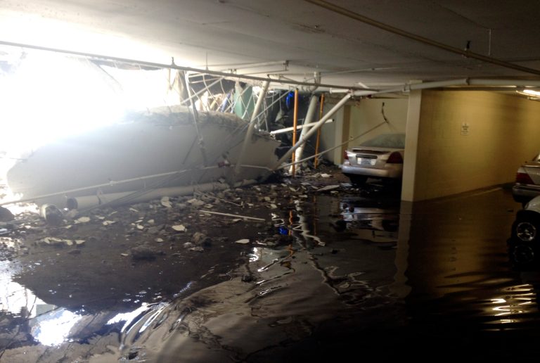 This image provided by Los Angeles Fire Department shows a partially collapsed parking structure in Los Angeles on Friday, July 25, 2014. A fire spokesman said a large planter fell from a crane, causing the collapse Friday morning. (AP Photo/Los Angeles Fire Department)