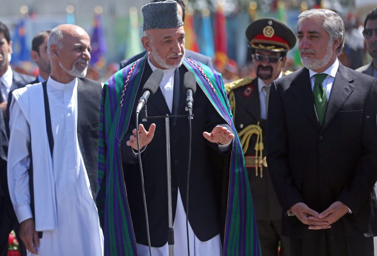 Afghan President Hamid Karzai, center, speaks in  front of local and international media representatives as presidential candidates Abdullah Abdullah, right, and Ashraf Ghani Ahmadzai, left , listen during the Independence Day ceremony in Kabul, Afghanistan, Tuesday, Aug. 19, 2014. King Amanullah won the country's independency from Britain in 1919. (AP Photo/Massoud Hossaini)