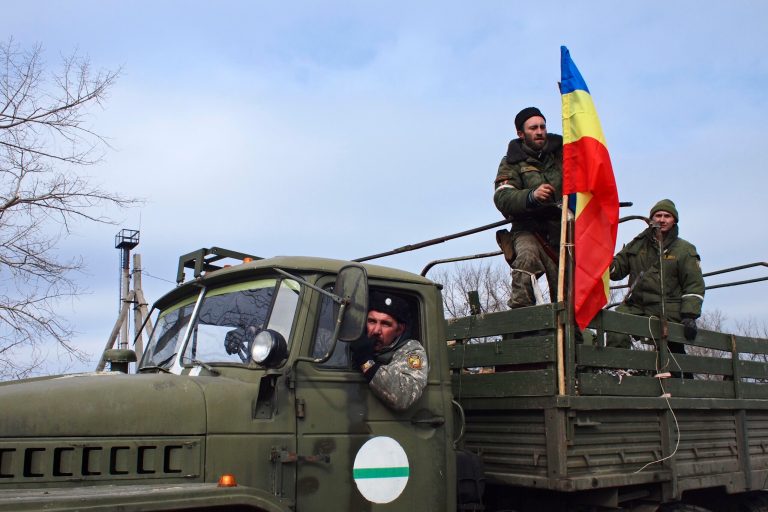 Pro-Russia rebels, one of them holding a flag of the rebel-held city of Luhansk, pose for a photo in Debaltseve, eastern Ukraine on Thursday, Feb. 19, 2015. (AP Photo/Peter Leonard)