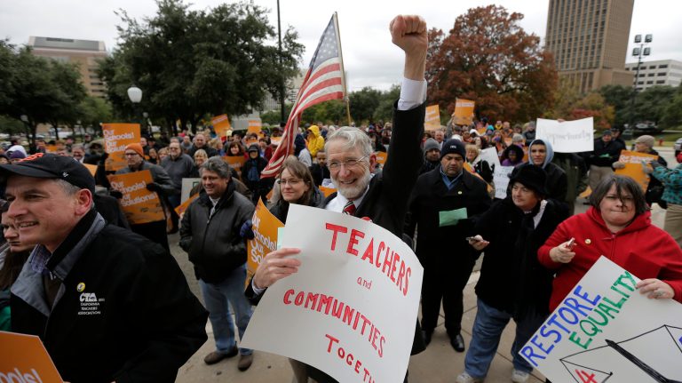 Teacher George Sheridan, center, and other supporters of public education take part in a rally on the steps of the state Capitol on Dec. 6, 2013, in Austin, Texas. (AP Photo/Eric Gay)